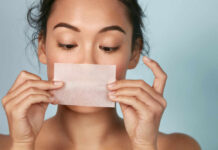 Woman holding a skincare strip in front of her face