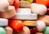 Breakthrough Drug Ends Relentless Infection Cycle A close-up view of a variety of colorful pills and tablets stacked together