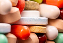A close-up view of a variety of colorful pills and tablets stacked together