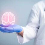 A medical professional holding a glowing digital brain illustration in their hand