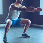 Man performing a squat exercise in a gym