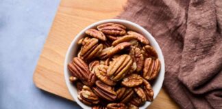 Bowl of pecans on a wooden cutting board