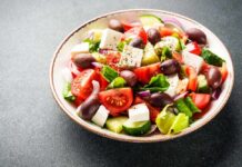 A vibrant salad with tomatoes, cucumbers, olives, and feta cheese