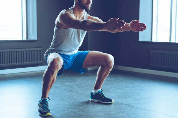 Man performing a squat exercise in a gym