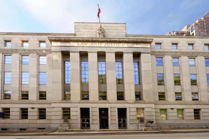 Facade of a government building with the words Law and Justice and a statue on top