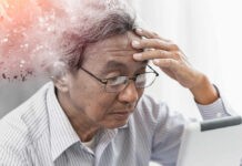 Elderly man looking stressed while using a digital device