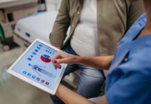 Hidden Risks of Low Muscle Mass Nurse showing a patient health data on a tablet