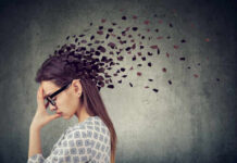 Everyday Plastic Linked To Lifelong Anxiety A woman with glasses holding her head, with fragments dispersing from her head