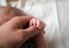 Experts Call Daycare ‘Absolutely Terrible’ For Children A close-up of a babys hand being held by an adult hand
