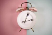 Fasting Over 50: Hidden Dangers? An alarm clock with a plate and two forks arranged in a creative design