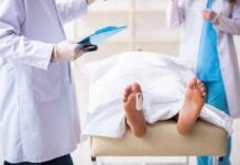 Household Chore Becomes A Death Trap Medical staff stand near a covered body on a gurney with a toe tag