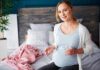 Prenatal Pills Quietly Rewired Kids’ Brains Pregnant woman sitting on bed holding pills and a glass of water