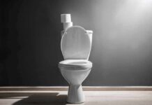 White toilet with open lid against gray wall