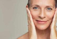Sunscreen Myths That Could Cost You Your Face Close-up portrait of a smiling woman gently holding her face