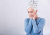 Aging Brains Scarred By Negativity Elderly woman with a unique hairstyle made of puzzle pieces, looking thoughtful