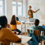Teacher explaining a math concept to students in a classroom