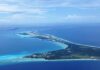 Travel Habit Tied To Longer Life Aerial view of a tropical island surrounded by blue ocean waters