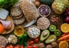 Tiny Snack Outsmarts Spinach On Iron A variety of fresh foods including vegetables, fruits, grains, and proteins arranged on a wooden surface