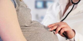 Pregnant woman examined with stethoscope