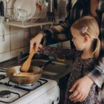 Child cooking with adult at a stove