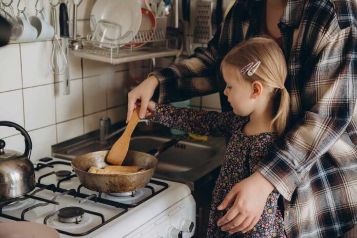 Child cooking with adult at a stove