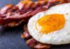 Lowering Bad Cholesterol: Cardio vs Weights? Fried egg with crispy bacon on dark surface