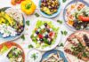 Greek meze spread with salad, olives, pita, and grilled skewers