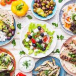 Greek meze spread with salad, olives, pita, and grilled skewers