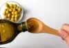 Diabetes Danger Hiding In Common Diet Fat Pouring olive oil from a bottle into a wooden spoon
