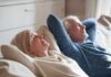 Two adults relaxing on a couch with eyes closed