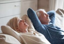 White Noise Warning Upends Common Sleep Health Advice Two adults relaxing on a couch with eyes closed