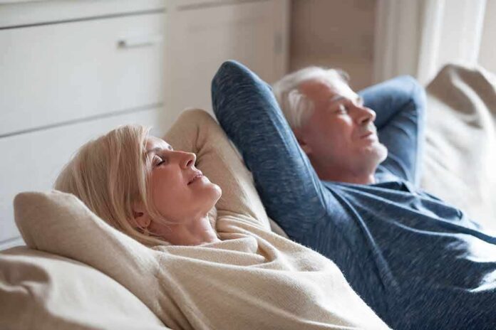 Two adults relaxing on a couch with eyes closed