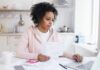 Effects Of A Higher Pay On Stress Woman reviewing bills at a kitchen table with a laptop