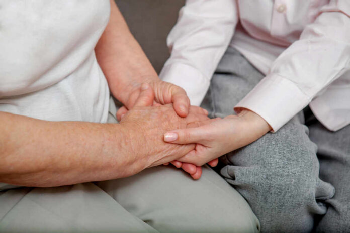 9a3727d6-ff70-4c52-bc15-2dd3fe515569_shutterstock2279066125jpg An older persons hand being held by a younger persons hand, symbolizing care and connection