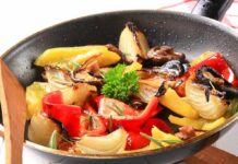A skillet filled with colorful stir-fried vegetables including onions and bell peppers