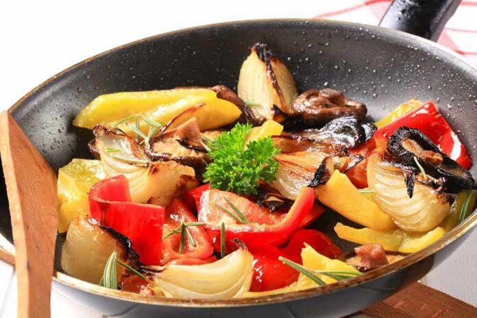 c0e4d3fd-3b50-4cd9-b02f-4e9933d13d92_shutterstock_113282938 A skillet filled with colorful stir-fried vegetables including onions and bell peppers