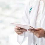 Doctor with stethoscope using a tablet