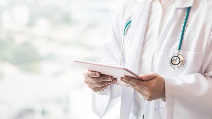 shutterstock_1034282797-1 Doctor with stethoscope using a tablet