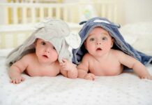 Ultra-Rare Twin Birth Stuns Minnesota two babies under hooded towels on a bed