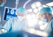 Surgeons in operating room under bright surgical lights