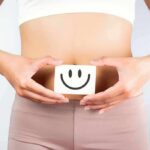 torso of person holding smiley card over stomach