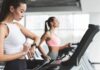 Woman on treadmill checking smartwatch in gym