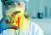 Scientist holding a test tube with red liquid