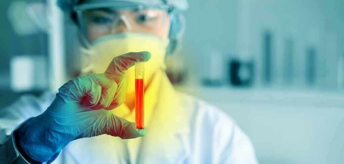 shutterstock_1630815484 Scientist holding a test tube with red liquid