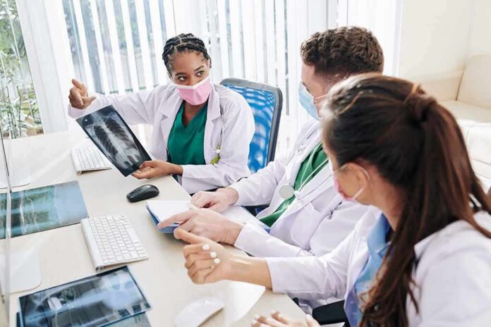 Doctors reviewing chest X-ray at a workstation