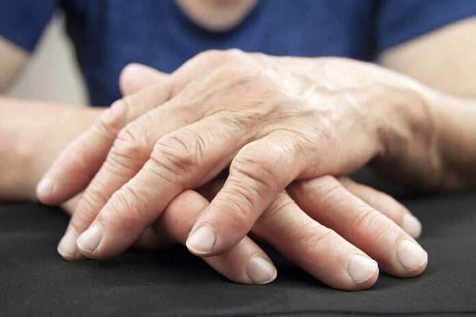 Elderly hands resting and crossed on a dark surface