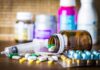 Popular BP Pill Tied To Kidney Danger Medicine pills and syringe on table with brown bottle