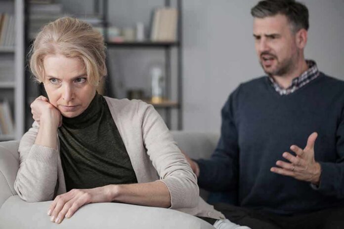 shutterstock_1011165355 Upset woman sitting on couch while man gestures behind her