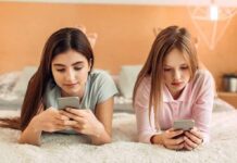Scroll Trap Linked To Memory Slide Two girls lying on a bed using smartphones