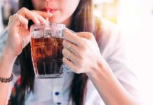 Diet Soda Byproduct Rips Human DNA person sipping iced drink from a glass mug with a straw